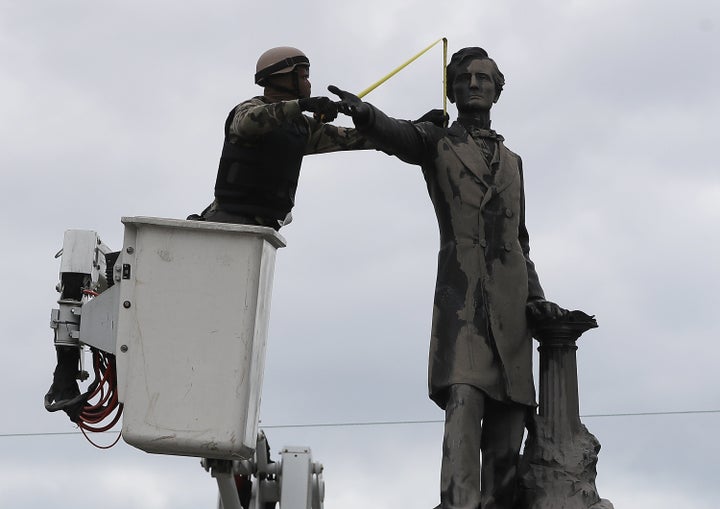 A New Orleans city worker wearing body armor and a face covering measures the Jefferson Davis monument on May 4 after a Louisiana House committee voted to advance a bill that would forbid the removal of Confederate monuments in the state. The city removed four Confederate monuments in April. 