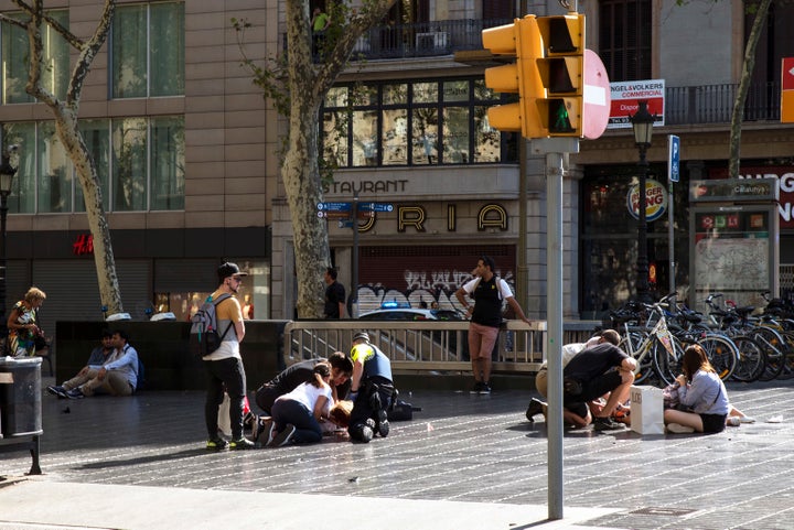 Injured people are tended to near the scene of a terrorist attack in the Las Ramblas area Thursday in Barcelona.