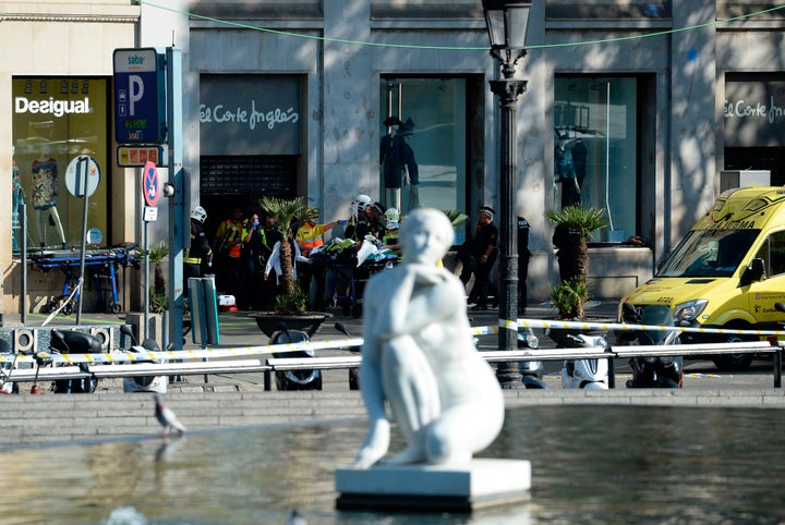 A person is stretched out of a mall by medical staff members in a cordoned off area after a van ploughed into the crowd on Friday 