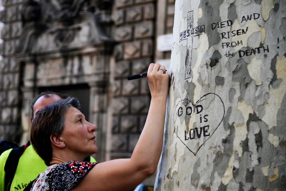 A woman writes a message on a tree at Plaza de Catalunya on Friday