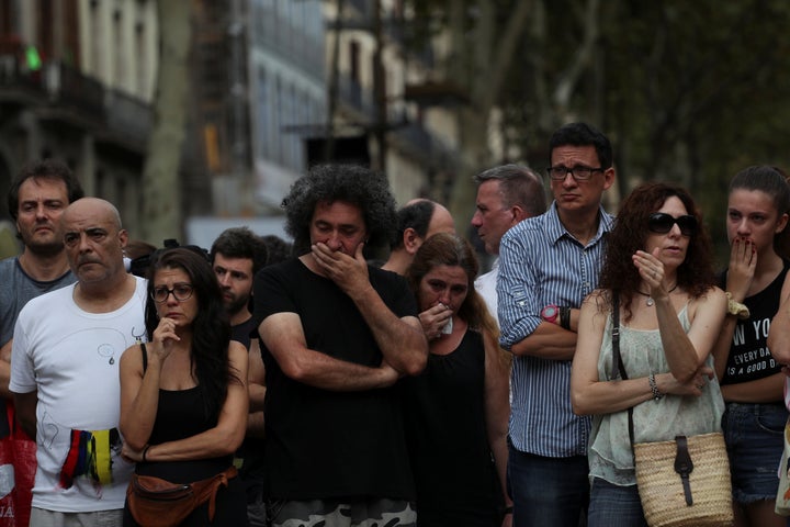 People stand at a memorial where the van crashed into pedestrians.