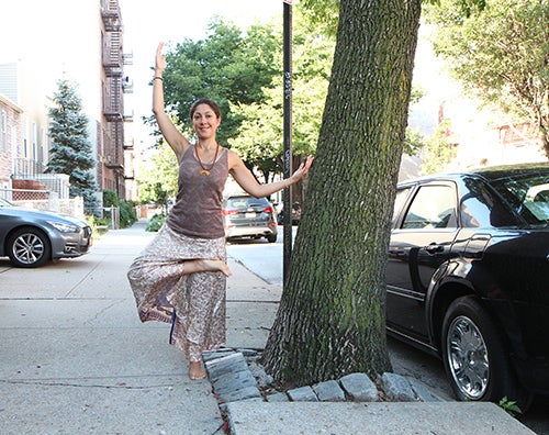 <strong>Sylvia doing a tree pose at a tree.</strong>