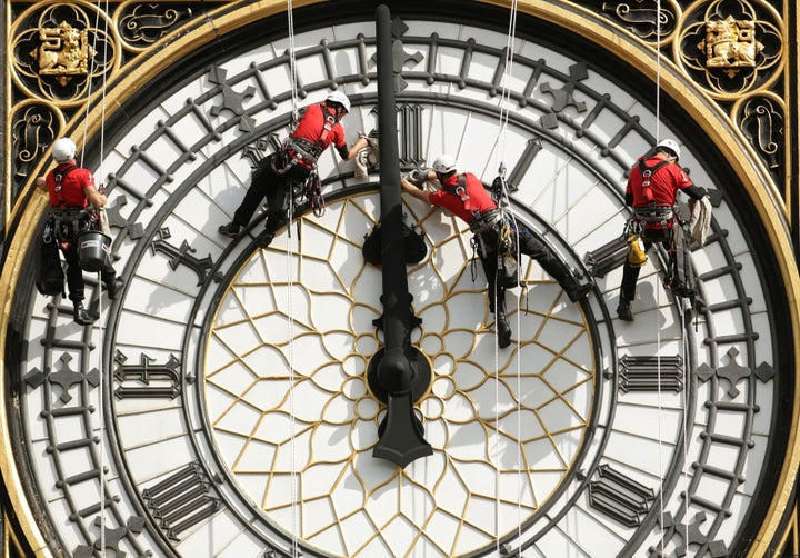 A team of abseilers inspect and clean one of the clock faces: August 2014