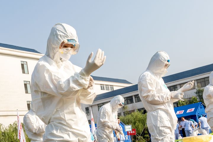Health workers act in an exercise dealing with an outbreak of H7N9 avian flu on June 17 in Hebi, China.