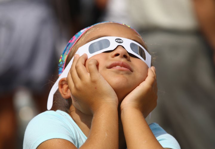 A young spectator looks skyward during a partial eclipse of the sun at the Cradle of Aviation Museum in Garden City, New York.