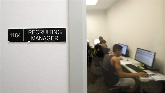 Job candidates fill out applications in the recruitment office at the Amazon fulfillment center in Robbinsville, N.J., earlier this month. Removing the question about criminal history from job applications may be hurting some minority job candidates.