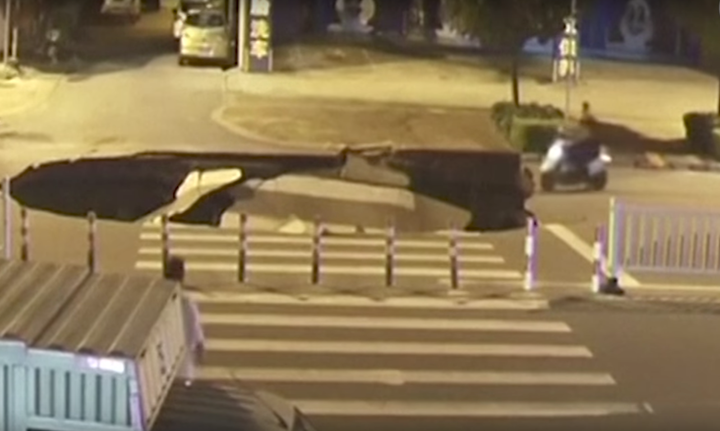 A man is seen driving a scooter straight into a sinkhole that opened up in China.