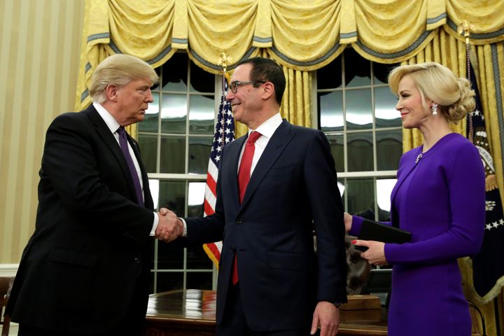 Donald Trump shakes hands with new Treasury Secretary Steve Mnuchin as Louise Linton looks on in the White House in February.