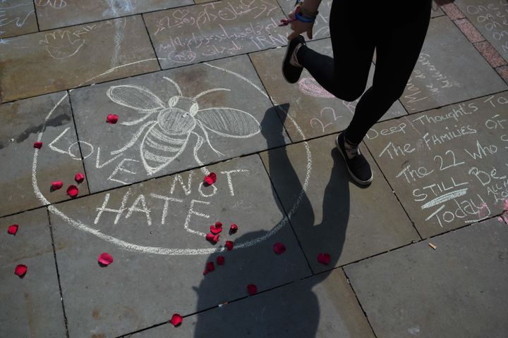 A person walks past a chalk message reading 'Love Not Hate' in St Ann's Square in Manchester, northwest England on May 25, 2017, placed in tribute to the victims of the May 22 terror attack at the Manchester Arena.