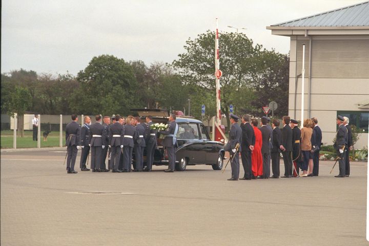 The coffin is carried off the plane at RAF Northolt 
