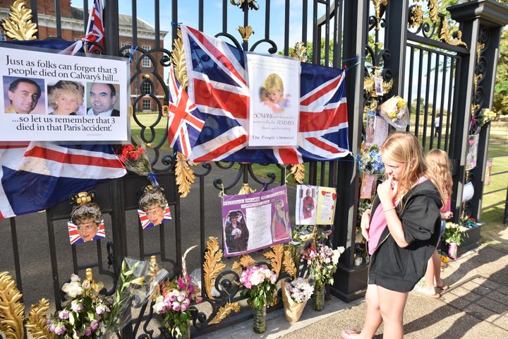 Flowers and tributes begin to appear at the gates of Kensington Palace 