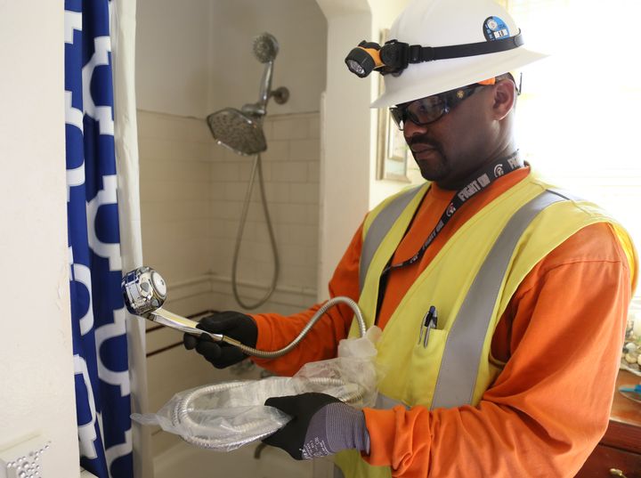 A union pre-apprenticeship program participant working with the Los Angeles Department of Water and Power installs a more energy efficient showerhead at an Angeleno’s home.