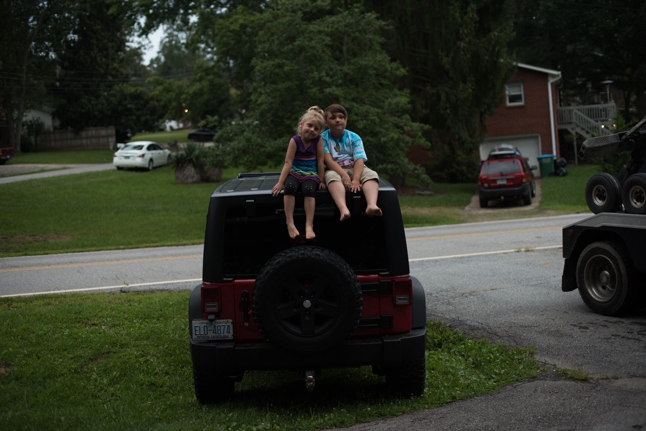 Emma and Miller on top of their dad's Jeep.