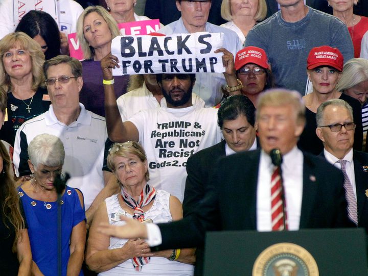 Maurice Symonette holds up his much noted sign behind President Trump at a rally in Arizona on Tuesday.