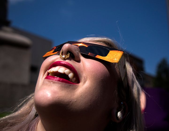 Angela Dispirito of Ware, N.H. watches the eclipse through solar glasses at Monument Square on Monday, August 21, 2017. 