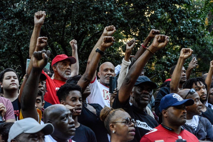 Rally attendees stand, fists raised, expressing solidarity with former San Francisco 49er Colin Kaepernick in his quest for r