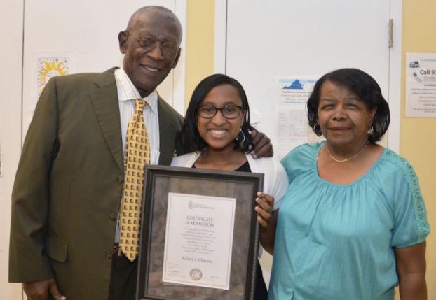 A student receives a scholarship from Dr. Rick Turner and current Albemarle-Charlottesville NAACP President Janette Martin on Aug. 8, 2016.