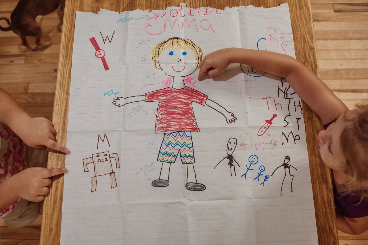 Emma's now-edited "About Me" day drawing. Phrases were added after the fact like "her hair is long not short," "the shirt was light pink with a heart" and "the shoes were pink and glitter not black."