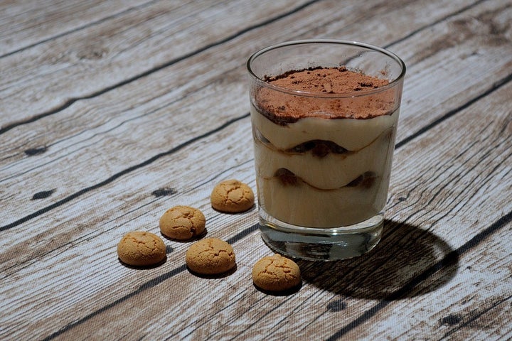 Tiramisù is made with coffee-soaked ladyfinger biscuits layered between whipped cream made of egg yolks, mascarpone cheese and sugar sprinkled with cocoa powder. 