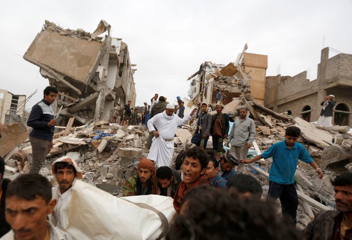People carry the body of woman they recovered from under the rubble of a house destroyed by a Saudi-led air strike in Sanaa, Yemen on Friday.