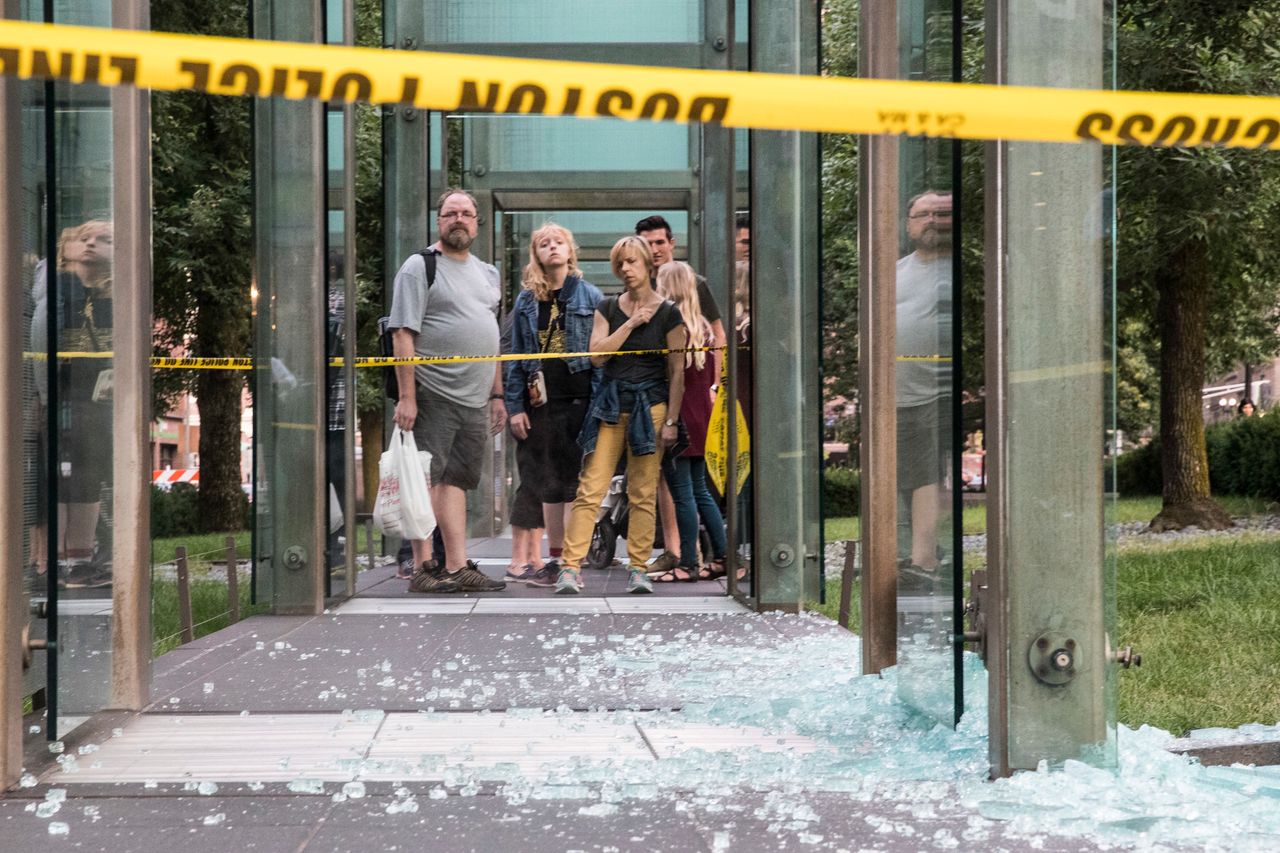 Passers-by look at glass shards on the ground from the New England Holocaust Memorial in Boston after it was vandalized on Aug. 14. 
