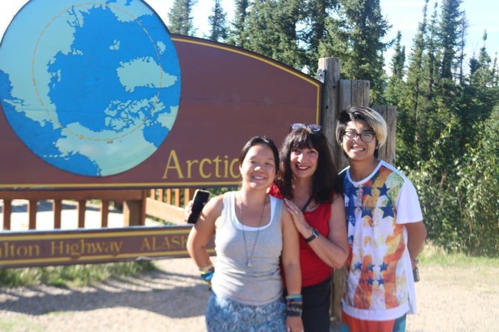 The author and her children in front of the marker for the Arctic Circle.