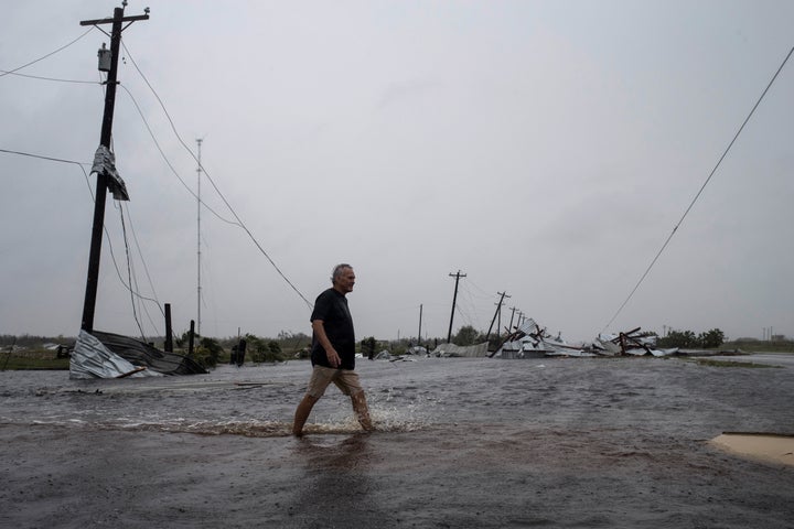 A man walks through floods waters after surveying his property, which was hit by Hurricane Harvey in Rockport, Texas.