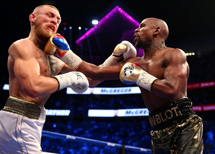 Floyd Mayweather Jr. lands a hit against Conor McGregor during this morning's boxing match at T-Mobile Arena