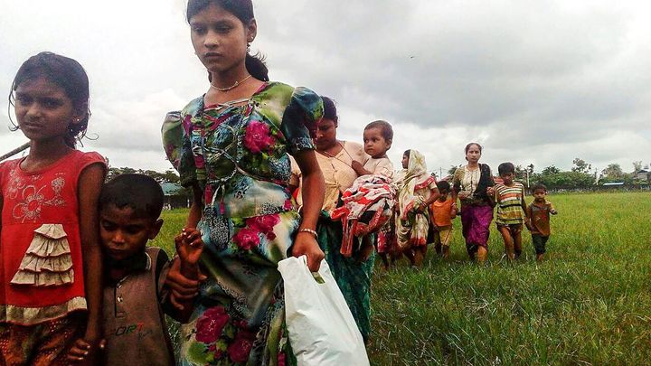 Women and children fleeing violence in their villages arrive at the Yathae Taung township in Rakhine State in Myanmar on August 26, 2017.