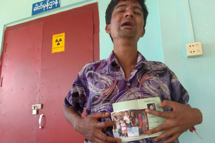 A man shows a picture of members of his family, whom he says were killed by Rohingya militants, at Maungdaw hospital on August 27, 2017.