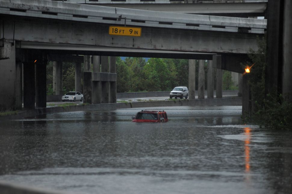 Floodwaters nearly cover an abandoned Hummer along Interstate 610 in Houston on Sunday.