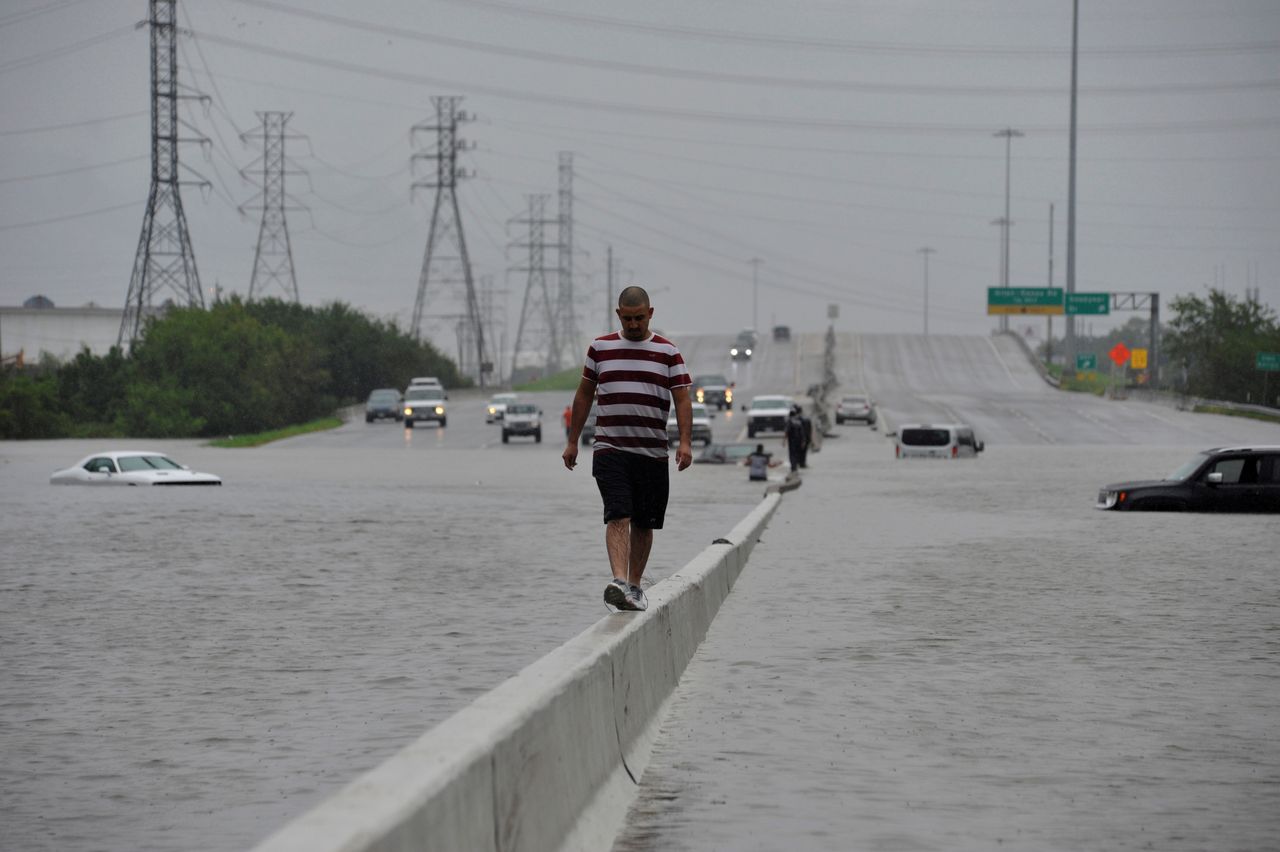 A stranded motorist escapes floodwaters on Interstate 225 in Houston on Sunday.