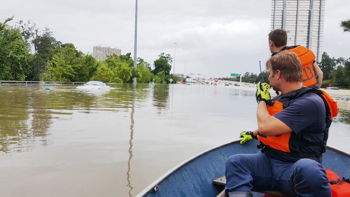 Firefighters with the Houston Fire Department check on a submerged vehicle off Interstate 10 in Houston on Sunday.