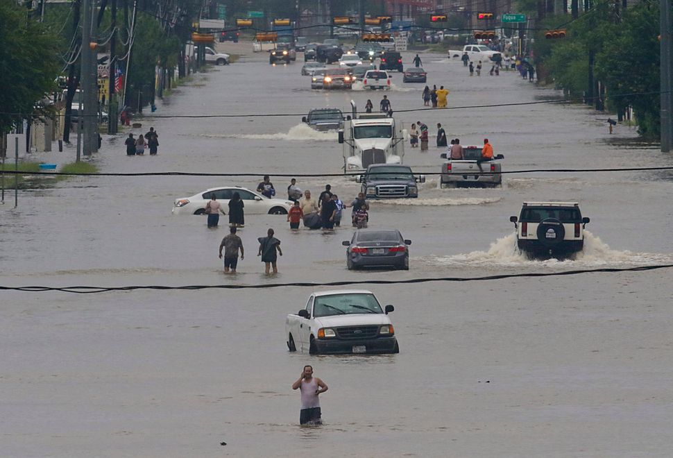 People walk through the flooded waters of Houston on Sunday.