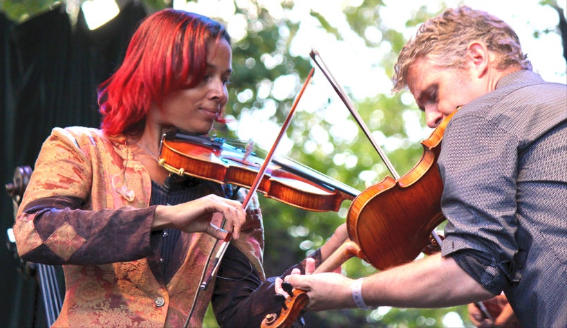 Rhiannon Giddens (left) and <em>Freedom Highway</em> co-producer and cowriter Dirk Powell play the fiddle on Aug. 18 at the 2
