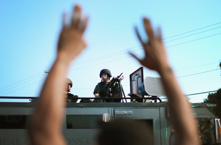 Police stand watch as demonstrators protest the shooting death of teenager Michael Brown on Aug. 13, 2014 in Ferguson, Missouri, sparking days of unrest in the community.