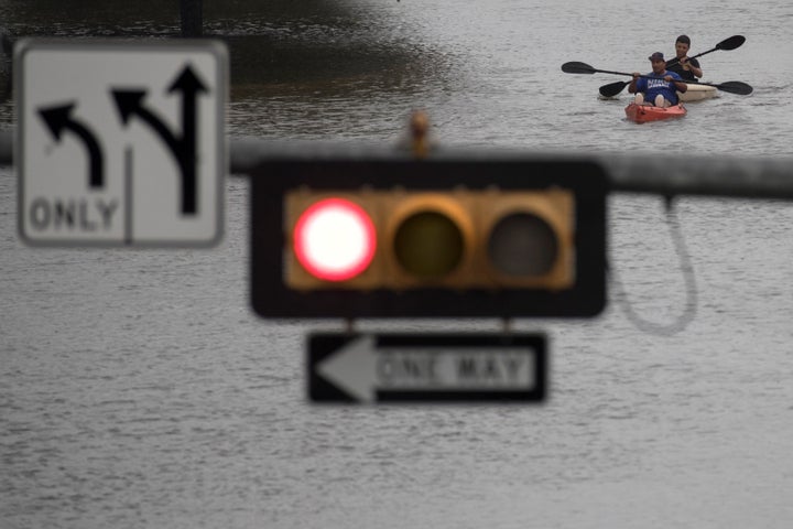 Men use kayaks to get through an intersection after heavy rain from Hurricane Harvey flooded Pearland, in the outskirts of Houston, on Aug. 27.