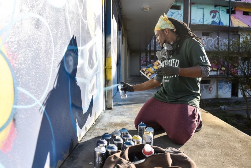 Brandan Odums spray-paints a wall for "Exhibit Be" in 2014.