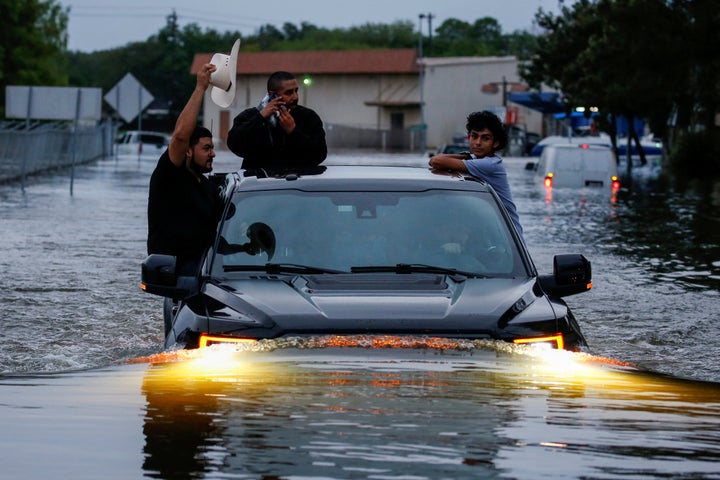 Residents use a truck to navigate through flood waters from Tropical Storm Harvey in Houston on Aug. 27.