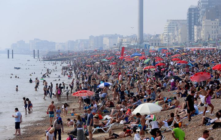 People enjoy the bank holiday sunshine on Brighton beach in Sussex.