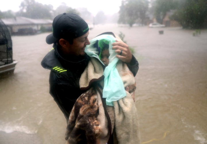 An infant is evacuated from a home in Houston on Monday. The Texas Diaper Bank is raising funds to help families with small children.