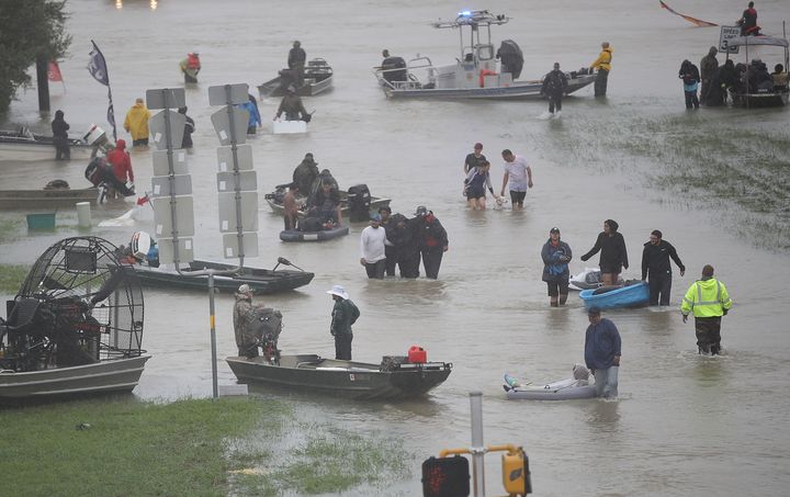 Evacuees wade through a flooded street in Houston on Monday.