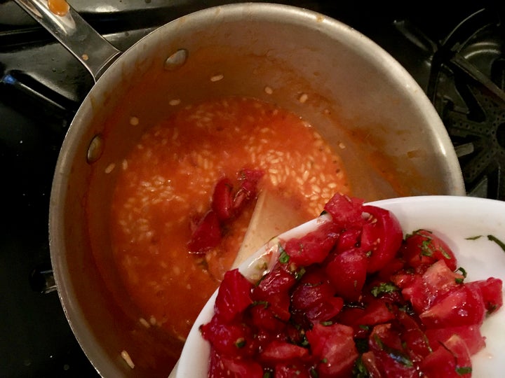 When the rice is nearing doneness, in go the quartered cherry tomatoes and basil