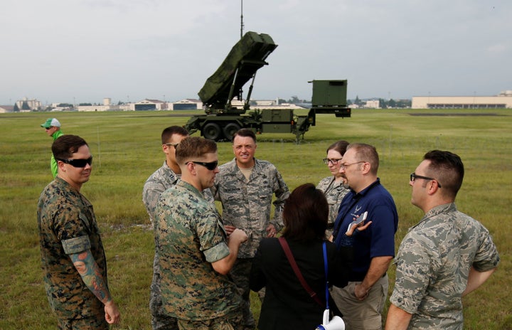 U.S. Forces officials are seen in front of a Japan Self-Defense Forces (JSDF) Patriot Advanced Capability-3 (PAC-3) missile u
