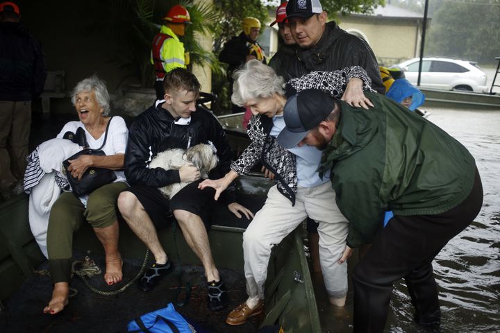 Rescuers help a woman from a flooded retirement home into a boat after Hurricane Harvey in Spring, Texas