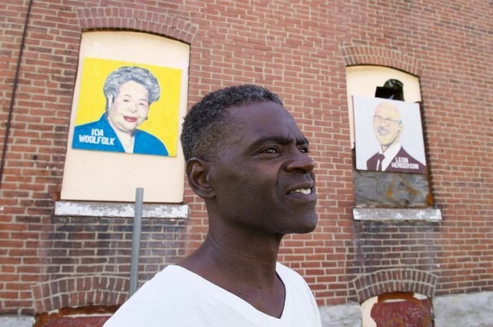 Green poses with some of his paintings.