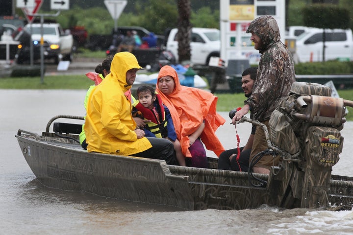 Rescue workers and volunteers help residents make their way out of a flooded neighborhood after it was inundated with rain water following Hurricane Harvey on Aug. 29 in Houston. 