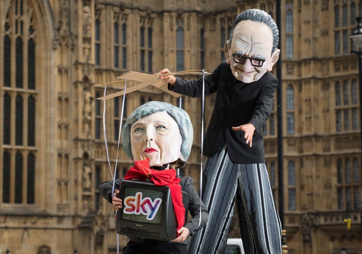 Campaigners from Avaaz dressed as Prime Minister Theresa May and Rupert Murdoch take part in a demonstration outside the Houses of Parliament