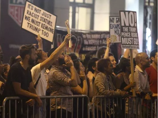 <p>Anti-Trump protesters hold signs near Trump Tower in New York on Aug. 15, 2017. </p>