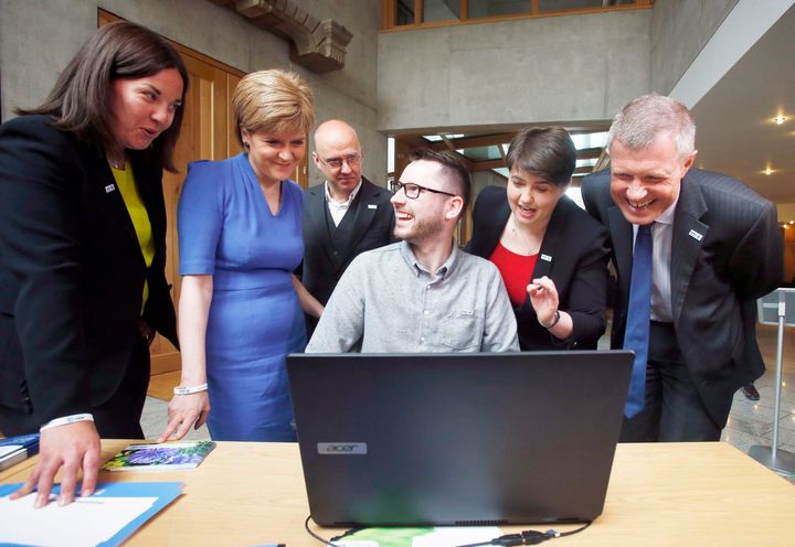 Motor Neurone Disease patient and campaigner Gordon Aikman (centre) meets politicians (left to right) Kezia Dugdale Scottish Labour leadership candidate, First Minister Nicola Sturgeon, Patrick Havey Scottish Green Party leader, Ruth Davidson Scottish Conservative leader and Willie Rennie Scottish Liberal Democracy leader during a photocall at the Scottish Parliament in Edinburgh